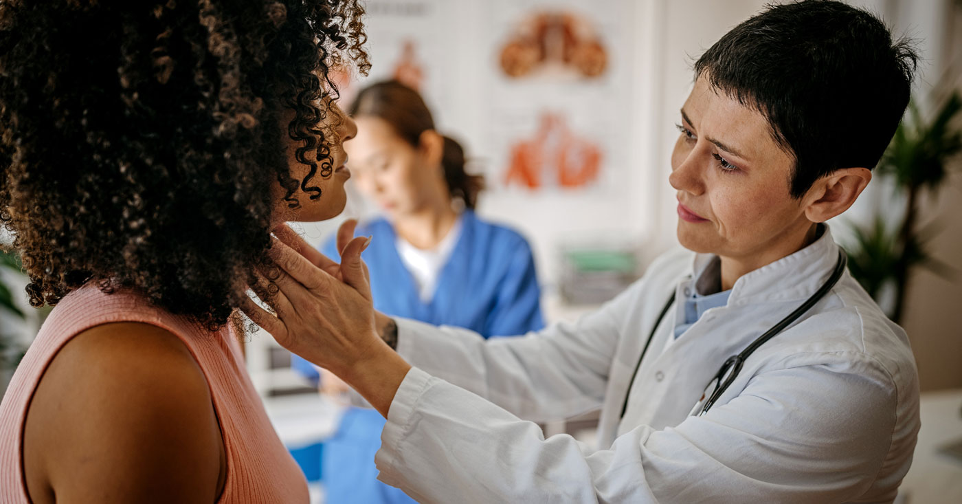 Doctor examing thyroid.