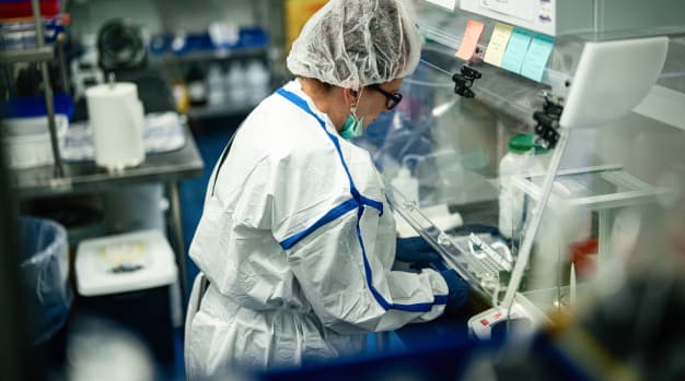 Pharmacist In Protective Gear Working In Lab Biosafety Cabinet